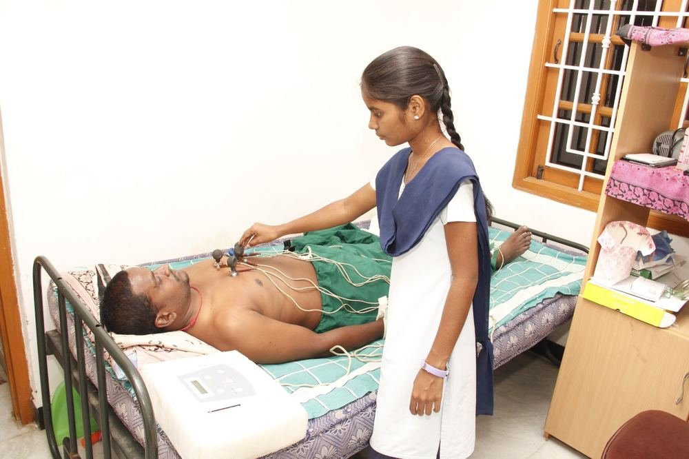 Technician preparing a patient for an ECG test at Dhanyaa Medical Centre